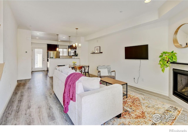 1240 Wren Ct Unit D, Longmont, CO 80501 - living room with light wood finished floors, a glass covered fireplace, recessed lighting, and baseboards