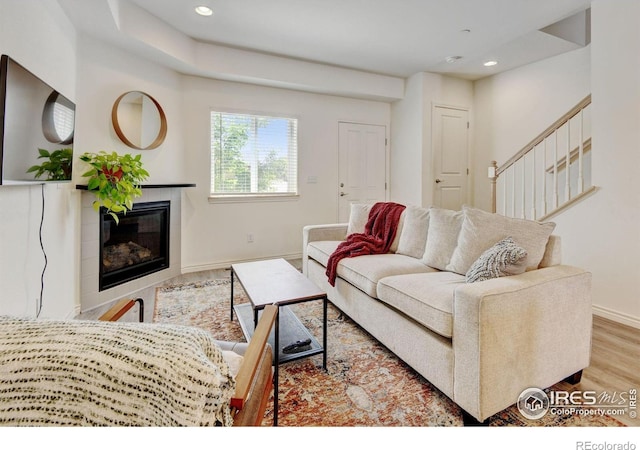 1240 Wren Ct Unit D, Longmont, CO 80501 - living area with baseboards, wood finished floors, a tile fireplace, recessed lighting, and stairway