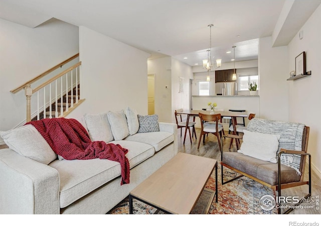 1240 Wren Ct Unit D, Longmont, CO 80501 - living room with wood finished floors, stairway, recessed lighting, a chandelier, and baseboards