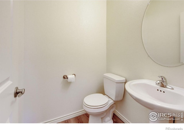1240 Wren Ct Unit D, Longmont, CO 80501 - bathroom featuring toilet, wood finished floors, baseboards, and a sink