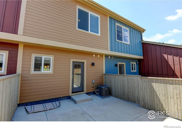 1240 Wren Ct Unit D, Longmont, CO 80501 - rear view of house with cooling unit, a patio area, and board and batten siding