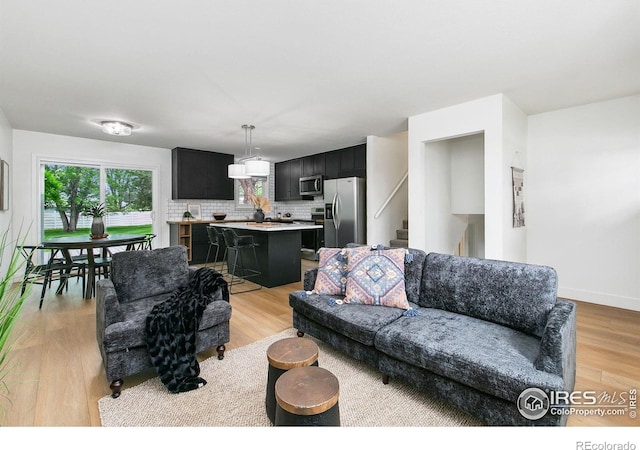 4329 Main St, Timnath, CO 80547 - living room featuring healthy amount of natural light, light wood-type flooring, and stairs