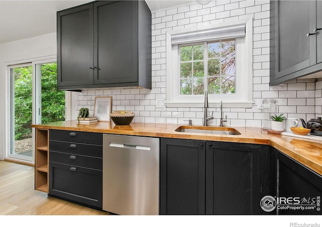 4329 Main St, Timnath, CO 80547 - kitchen with dishwasher, butcher block counters, a sink, tasteful backsplash, and light wood finished floors