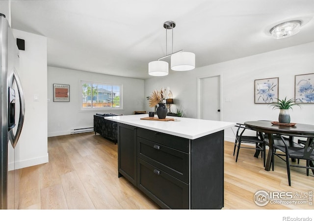 4329 Main St, Timnath, CO 80547 - kitchen with stainless steel fridge, dark cabinets, baseboard heating, and light wood-style flooring