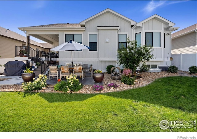 4521 Devereux Dr, Windsor, CO 80550 - rear view of house featuring a patio area, a lawn, and board and batten siding