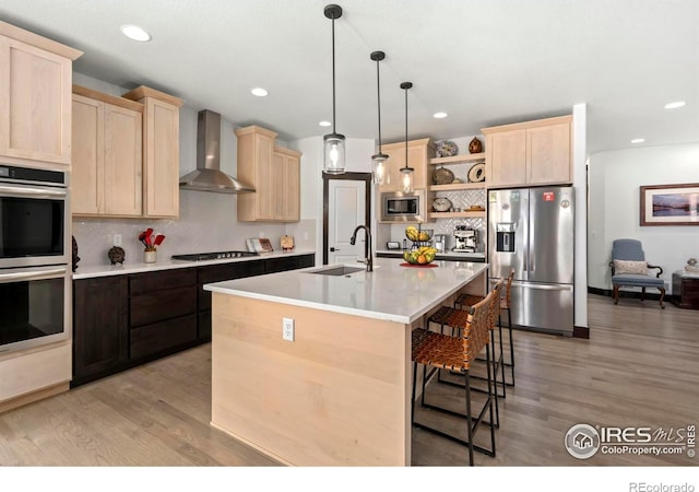 4521 Devereux Dr, Windsor, CO 80550 - kitchen with appliances with stainless steel finishes, wall chimney range hood, light brown cabinetry, open shelves, and tasteful backsplash