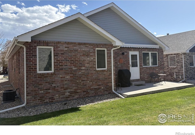 2126 Friar Tuck Ct, Fort Collins, CO 80524 - back of property with brick siding, a lawn, and central AC unit