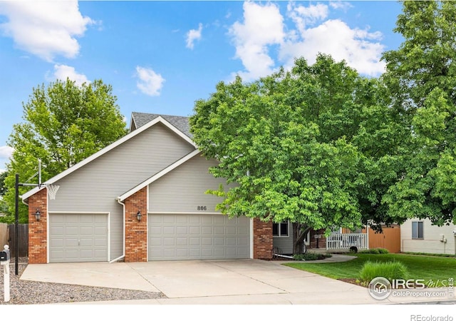 806 51st Ave, Greeley, CO 80634 - view of property hidden behind natural elements featuring a garage, brick siding, and driveway