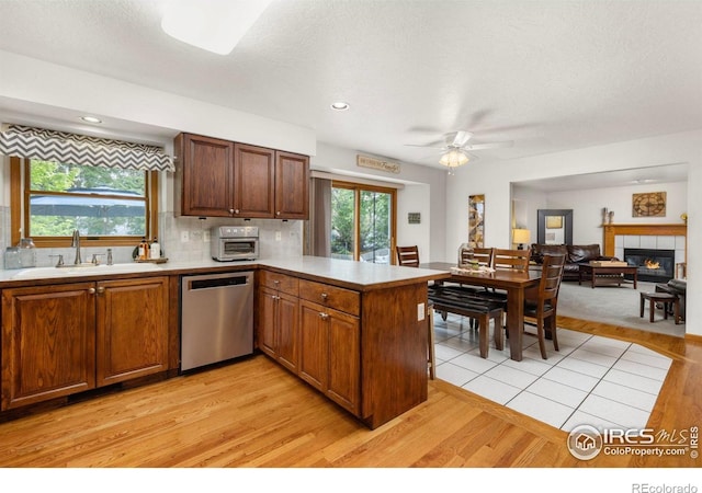 806 51st Ave, Greeley, CO 80634 - kitchen with stainless steel dishwasher, a peninsula, light wood-style flooring, light countertops, and ceiling fan