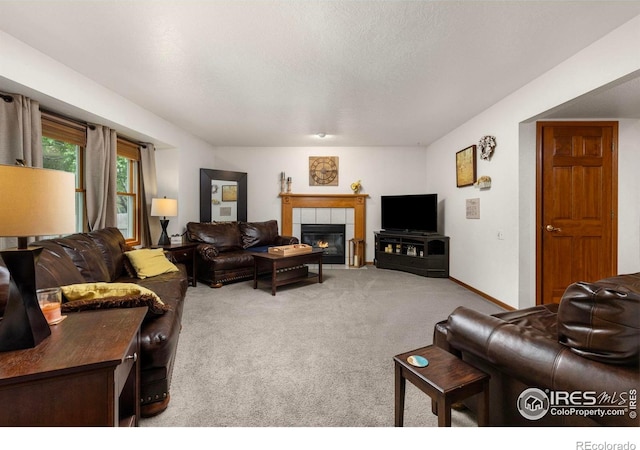 806 51st Ave, Greeley, CO 80634 - living room with light carpet, a tile fireplace, and a textured ceiling