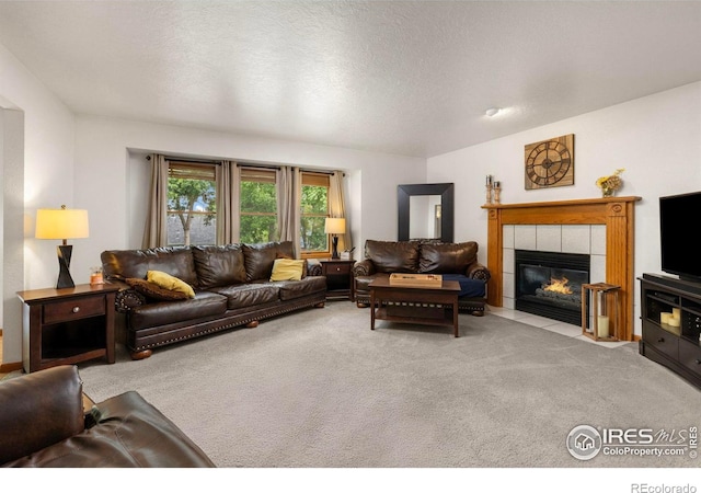 806 51st Ave, Greeley, CO 80634 - carpeted living area with a tiled fireplace and a textured ceiling