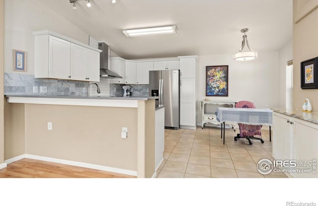 856 Sunchase Dr, Fort Collins, CO 80524 - kitchen with wall chimney exhaust hood, stainless steel fridge with ice dispenser, tasteful backsplash, a peninsula, and white cabinetry