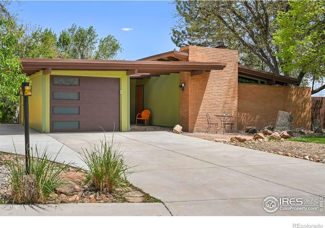 5450 Mohawk Rd, Littleton, CO 80123 - mid-century modern home featuring driveway and an attached garage