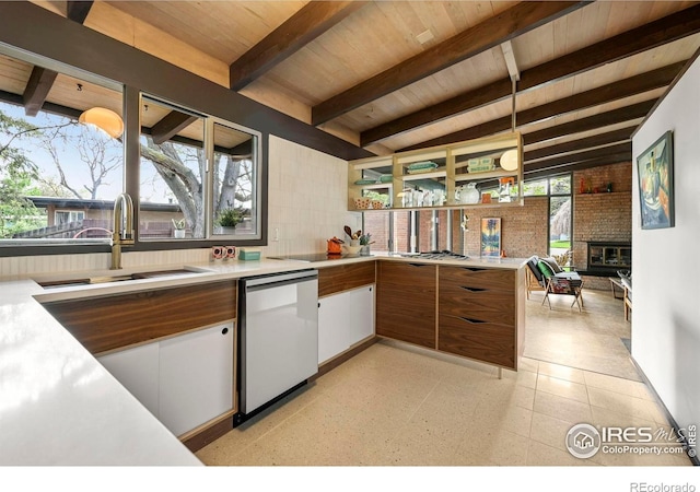 5450 Mohawk Rd, Littleton, CO 80123 - kitchen with a sink, dishwashing machine, light countertops, wood ceiling with exposed beams, and a brick fireplace