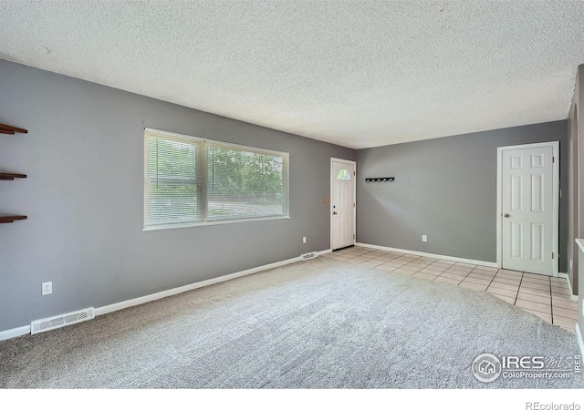 701 Elm St, Windsor, CO 80550 - carpeted empty room with a textured ceiling, baseboards, and tile patterned floors