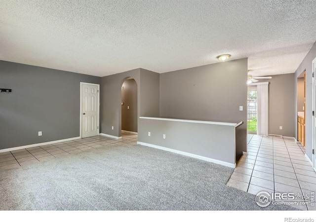 701 Elm St, Windsor, CO 80550 - spare room with tile patterned flooring, arched walkways, a textured ceiling, ceiling fan, and baseboards