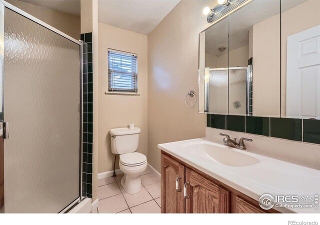 701 Elm St, Windsor, CO 80550 - full bath with toilet, a stall shower, tile patterned flooring, vanity, and baseboards