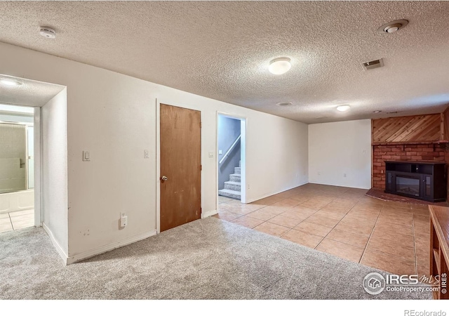 701 Elm St, Windsor, CO 80550 - unfurnished living room with stairs, tile patterned floors, carpet flooring, a glass covered fireplace, and a textured ceiling
