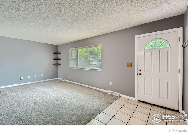 701 Elm St, Windsor, CO 80550 - entryway with a textured ceiling, baseboards, light tile patterned floors, and light carpet