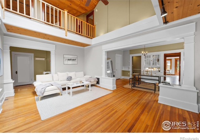 1020 10th St, Boulder, CO 80302 - living area featuring wood finished floors, a high ceiling, decorative columns, a chandelier, and wooden ceiling