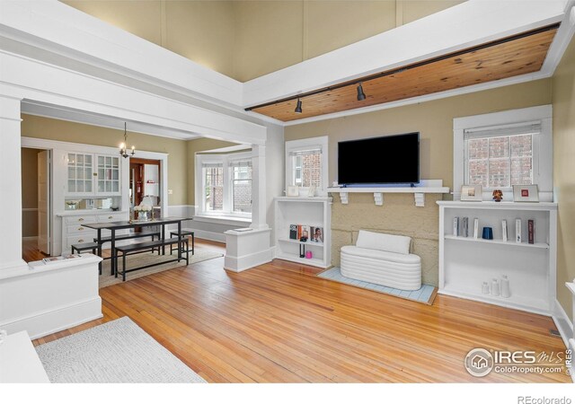 1020 10th St, Boulder, CO 80302 - living area with wood finished floors, a chandelier, ornamental molding, and ornate columns