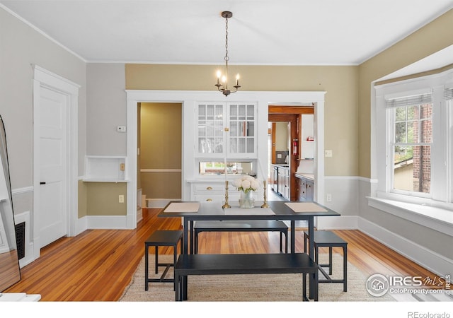 1020 10th St, Boulder, CO 80302 - dining area featuring light wood-style floors, a chandelier, baseboards, and crown molding