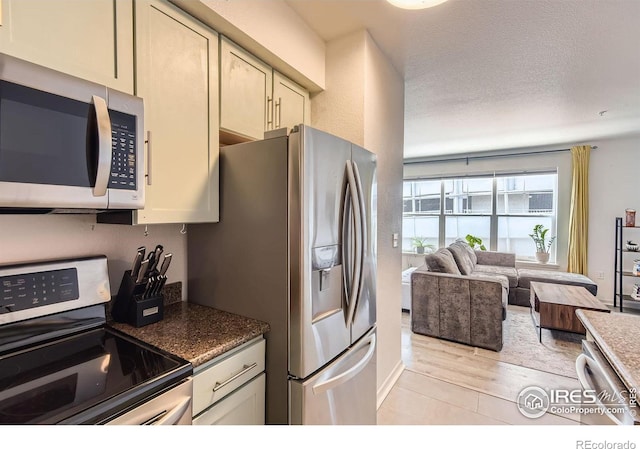 1623 Saint Paul St Unit 310, Denver, CO 80206 - kitchen with stainless steel appliances, open floor plan, and a textured ceiling