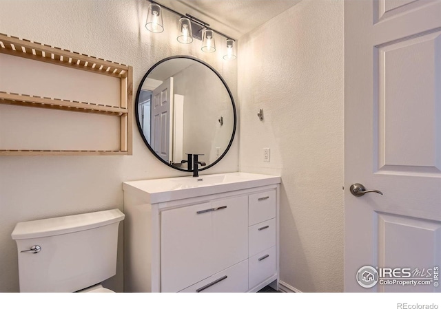 1623 Saint Paul St Unit 310, Denver, CO 80206 - bathroom featuring toilet, vanity, and a textured wall