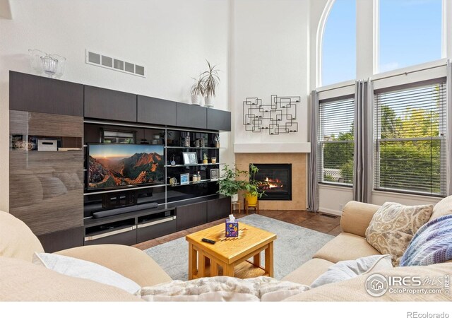 1706 Naples Ln, Longmont, CO 80503 - tiled living area featuring a towering ceiling and a fireplace