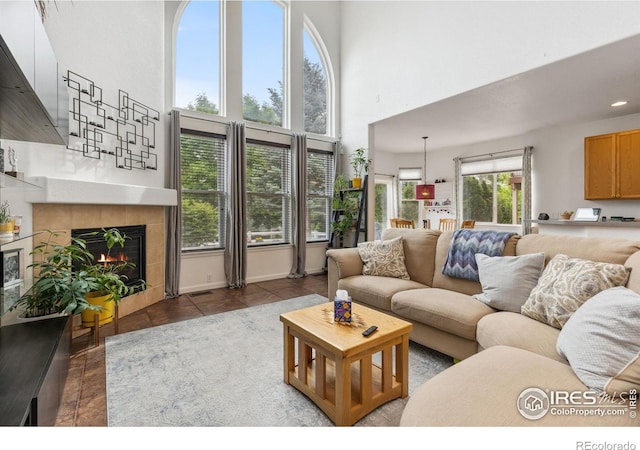 1706 Naples Ln, Longmont, CO 80503 - living room featuring a high ceiling, tile patterned flooring, a tile fireplace, recessed lighting, and baseboards