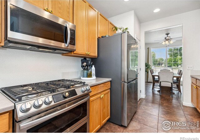 1706 Naples Ln, Longmont, CO 80503 - kitchen with appliances with stainless steel finishes, light countertops, ceiling fan, tile patterned floors, and recessed lighting