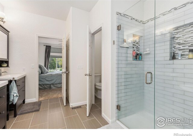 1706 Naples Ln, Longmont, CO 80503 - ensuite bathroom featuring vanity, a shower stall, toilet, and baseboards