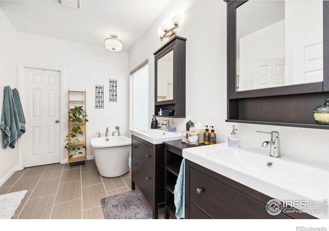 1706 Naples Ln, Longmont, CO 80503 - full bathroom featuring two vanities, a freestanding tub, and baseboards