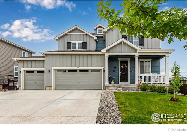 10 N Quantock St, Aurora, CO 80018 - view of front of home featuring a porch, a front yard, driveway, and board and batten siding