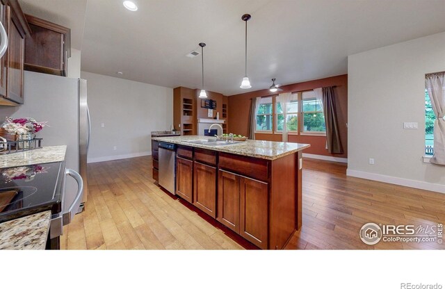 2107 Blackbird Dr, Fort Collins, CO 80525 - kitchen with light wood finished floors, appliances with stainless steel finishes, hanging light fixtures, and a center island with sink