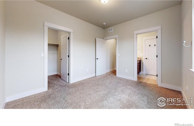 2107 Blackbird Dr, Fort Collins, CO 80525 - unfurnished bedroom with light carpet, a walk in closet, connected bathroom, and a closet