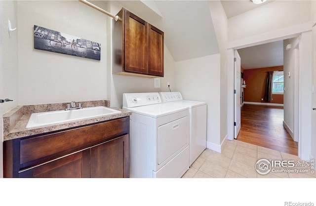 2107 Blackbird Dr, Fort Collins, CO 80525 - washroom featuring separate washer and dryer, cabinet space, and light tile patterned floors