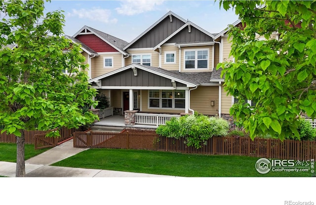 2107 Blackbird Dr, Fort Collins, CO 80525 - craftsman inspired home featuring board and batten siding, a fenced front yard, a porch, stone siding, and a shingled roof