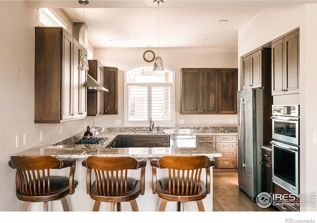 4993 Clubhouse Ct, Boulder, CO 80301 - kitchen with appliances with stainless steel finishes, a peninsula, wood finished floors, and pendant lighting