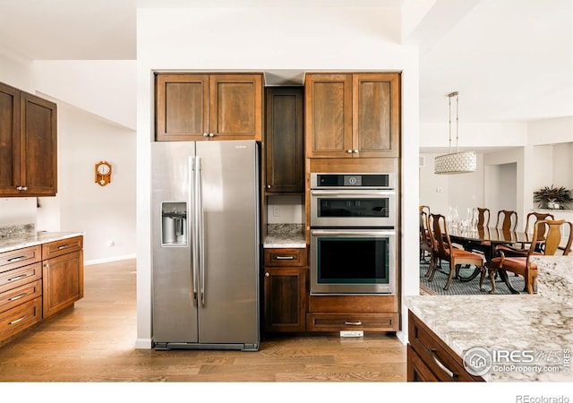 4993 Clubhouse Ct, Boulder, CO 80301 - kitchen featuring appliances with stainless steel finishes, light wood-type flooring, light stone counters, pendant lighting, and baseboards
