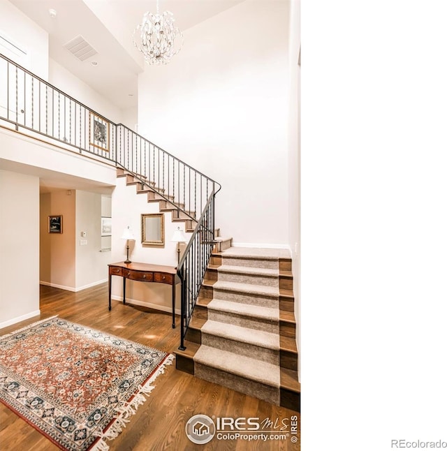 4993 Clubhouse Ct, Boulder, CO 80301 - stairway featuring wood finished floors, a chandelier, baseboards, and a high ceiling