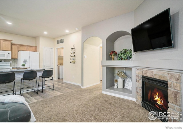 5551 29th St, Greeley, CO 80634 - living room with recessed lighting, a fireplace, light wood-type flooring, baseboards, and arched walkways
