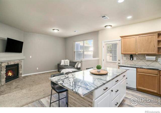 5551 29th St, Greeley, CO 80634 - kitchen featuring dishwasher, open floor plan, open shelves, light stone counters, and a kitchen island