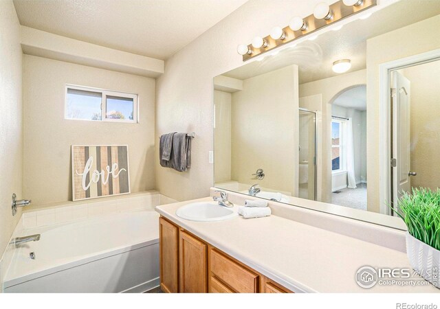 5551 29th St, Greeley, CO 80634 - full bathroom with a bath, plenty of natural light, vanity, and an enclosed shower