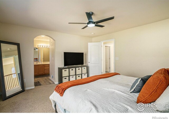 5551 29th St, Greeley, CO 80634 - bedroom with arched walkways, light colored carpet, baseboards, ensuite bath, and ceiling fan