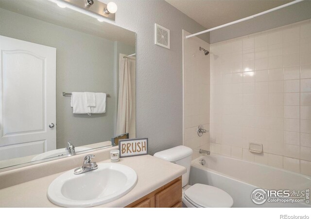 5551 29th St, Greeley, CO 80634 - bathroom with vanity, a textured wall, toilet, and shower / bath combination with curtain