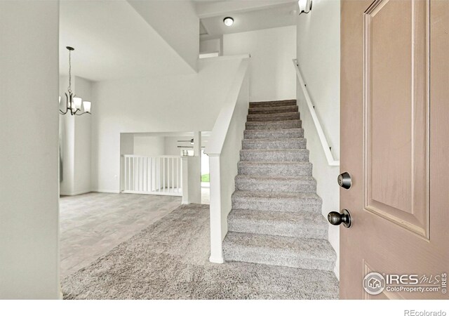 1711 101st Avenue Ct, Greeley, CO 80634 - stairway featuring a chandelier