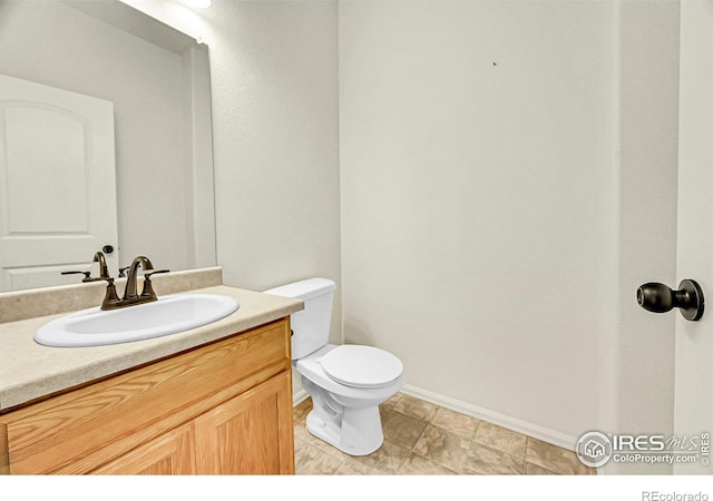 1711 101st Avenue Ct, Greeley, CO 80634 - bathroom with toilet, vanity, and baseboards