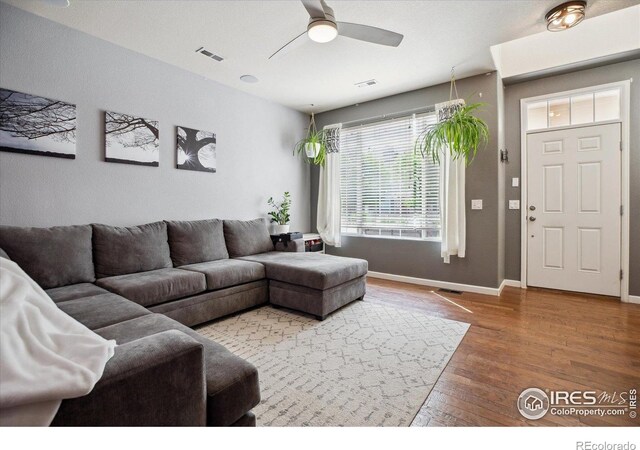 16031 W 63rd Ln W Unit D, Arvada, CO 80403 - living room featuring wood finished floors, a ceiling fan, and baseboards