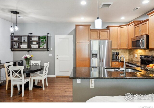 16031 W 63rd Ln W Unit D, Arvada, CO 80403 - kitchen with appliances with stainless steel finishes, a sink, dark stone counters, dark wood-style floors, and recessed lighting